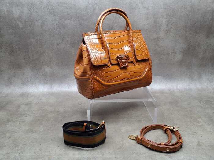 Designer-style handbag in brown with gold-tone hardware.