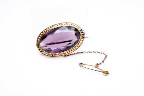 An antique purple paste brooch in 15 carat yellow gold