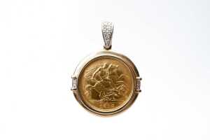 A 22 carat 1915 half sovereign in a 9 carat diamond pendant