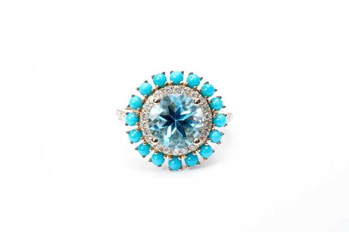 A blue topaz, diamond and turquoise ring in 14 carat yellow gold