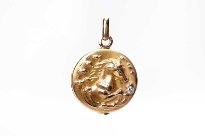 An antique diamond horse locket in 18 carat yellow gold.