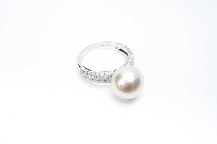A pearl and diamond ring in 14 carat white gold