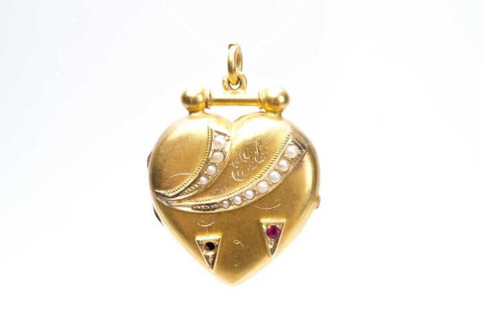 An antique ruby and seed pearl mourning locket in 15 carat yellow gold