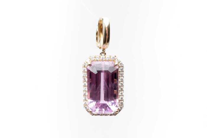 A kunzite and diamond enhancer pendant in 14 carat yellow gold
