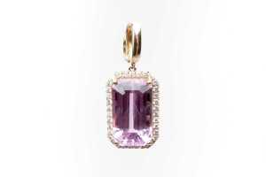 A kunzite and diamond enhancer pendant in 14 carat yellow gold