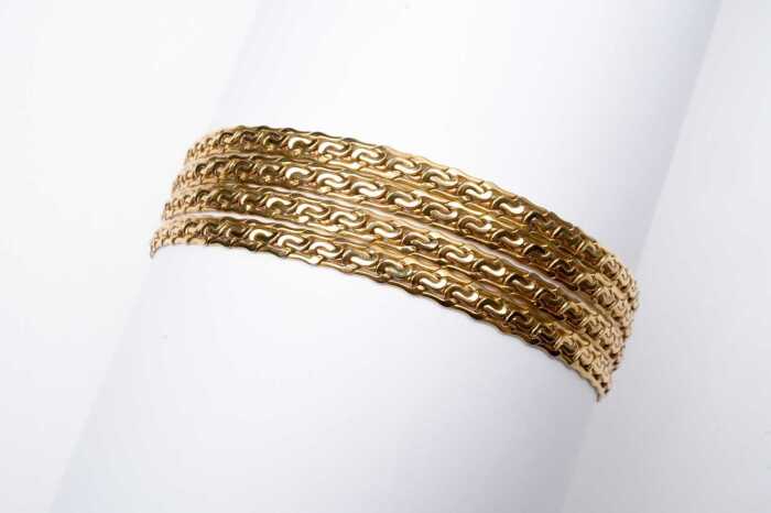 A four-strand fancy link bracelet in 9 carat yellow gold