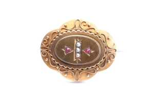 An antique seed pearl and garnet mourning brooch in 15 carat yellow gold