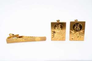 A cufflink and tie bar set in 14 carat yellow gold