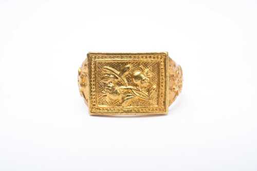 A carved ring in 24 carat yellow gold