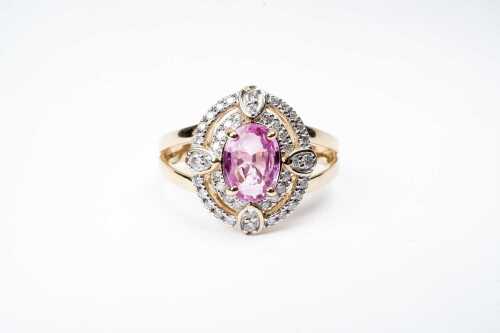 A pink sapphire and diamond ring in 14 carat yellow gold