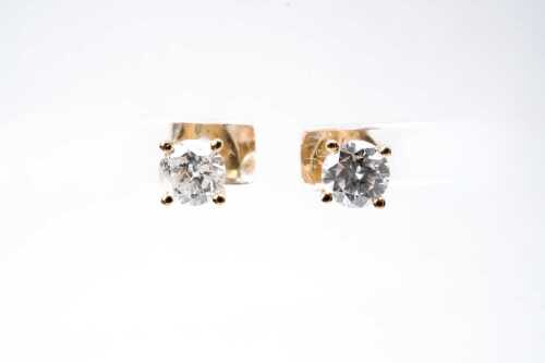 A pair of diamond stud earrings in 18 carat yellow gold