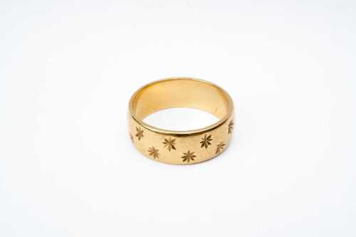 A vintage star patterned band in 18 carat yellow gold