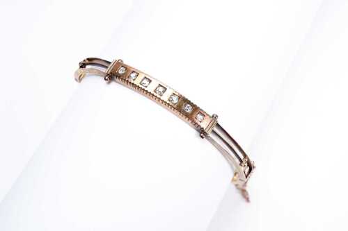 An antique diamond hinged bangle in 9 carat yellow gold