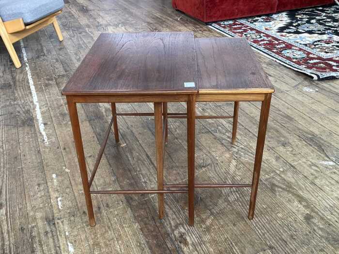 Two mid-century teak nesting side tables