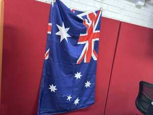 Two fabric Australian flags with timber poles.