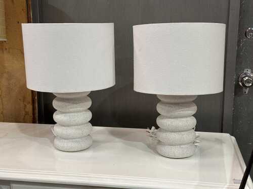 Pair of white ceramic lamps featuring a stacked-ring cylindrical shape base