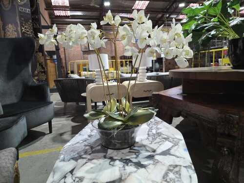 Artificial white orchid plant in a glass pot