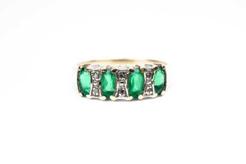An emerald and diamond ring in 9 carat yellow gold