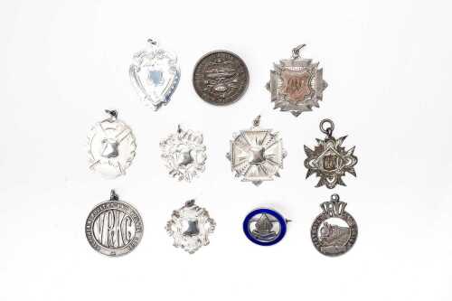 A collection of vintage and antique shields and brooches in sterling silver