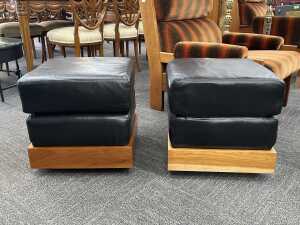 Pair of leather ottomans with timber plinth bases