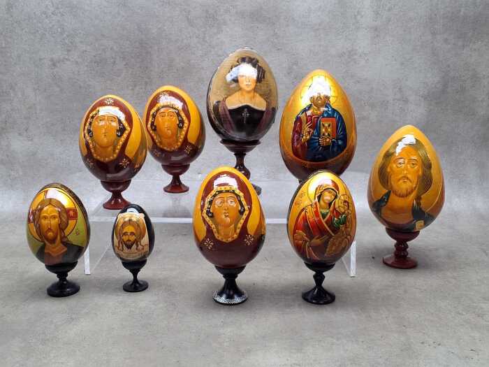 Nine Russian Orthodox hand-painted timber Easter eggs with stands.