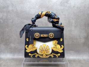 Designer-style black, white and gold tone handbag with gold tone hardware and bag scarf