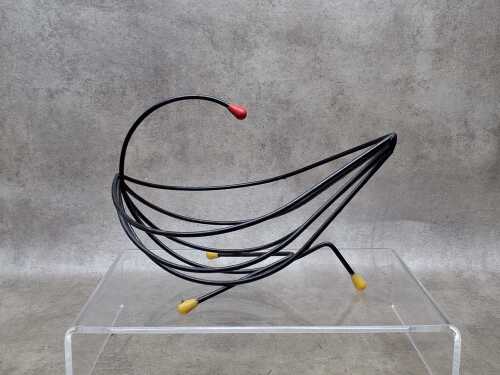Mid-century black wire fruit basket with yellow and red tips.