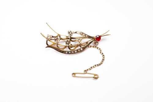 An antique seed pearl and garnet brooch in 9 carat yellow gold