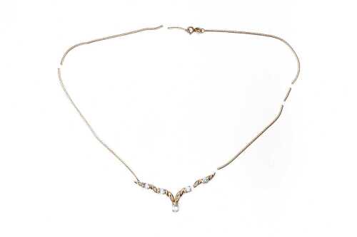 A broken blue topaz and diamond necklace in 9 carat yellow gold