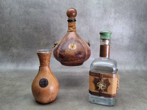 Three vintage Italian leather encased wine decanters