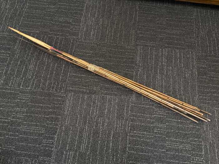 Collection of Papua New Guinea fishing spears with cane shafts and natural fibre bindings