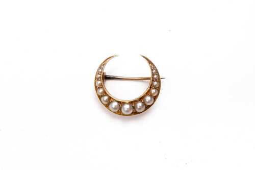 An antique crescent seed pearl brooch in 15 carat yellow gold