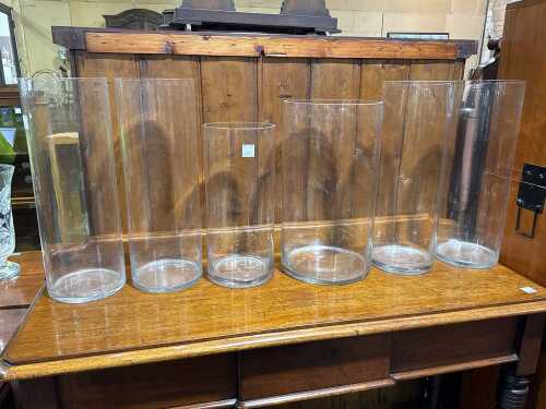 Six tall cylindrical clear glass vases