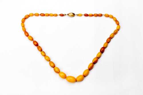 A strand of butterscotch amber to a 14 carat yellow gold clasp.