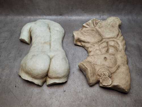 Two plaster wall-mounted sculptural torsos