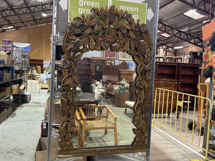 Whimsical mirror in heavily carved timber frame with gilded and sequined floral decoration