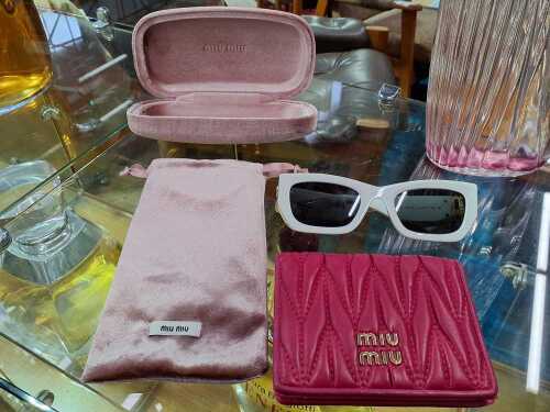 Designer-style items, including white sunglasses and a pink coin purse