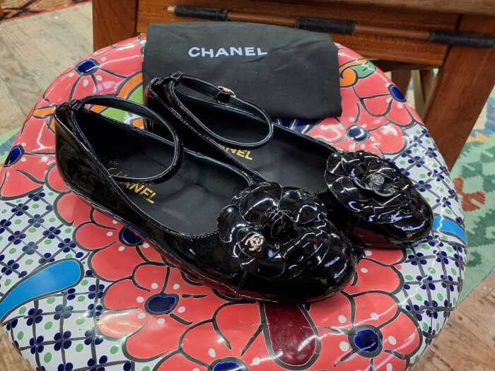 Designer-style black patent ballet flats with slip bag.