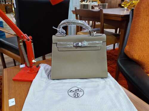 Designer-style handbag in taupe with silver-tone hardware.