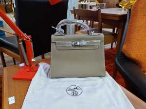 Designer-style handbag in taupe with silver-tone hardware.