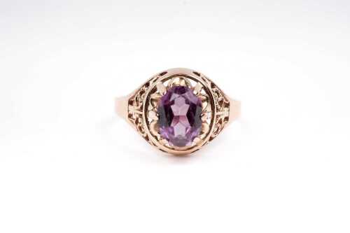A synthetic purple sapphire ring in 14 carat rose gold.