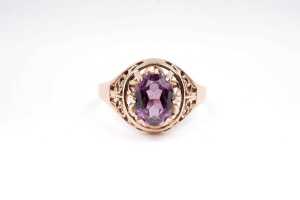 A synthetic purple sapphire ring in 14 carat rose gold.