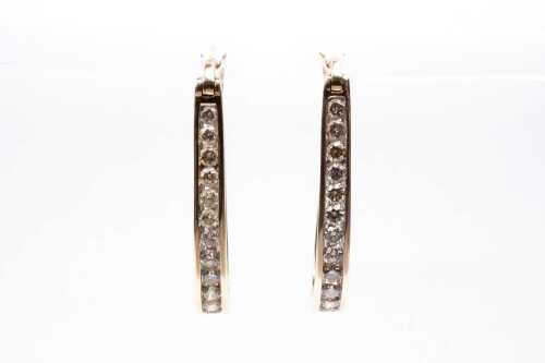 A pair of diamond hoops in 9 carat yellow gold