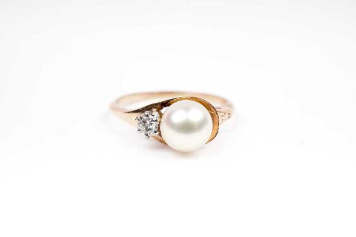 A pearl and diamond ring in 9 carat yellow gold