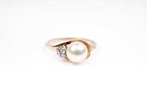 A pearl and diamond ring in 9 carat yellow gold