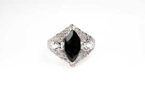 A green tourmaline, white topaz and diamond ring in 9 carat yellow gold