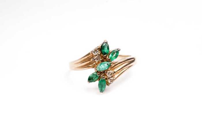 An emerald and diamond ring in 9 carat yellow gold