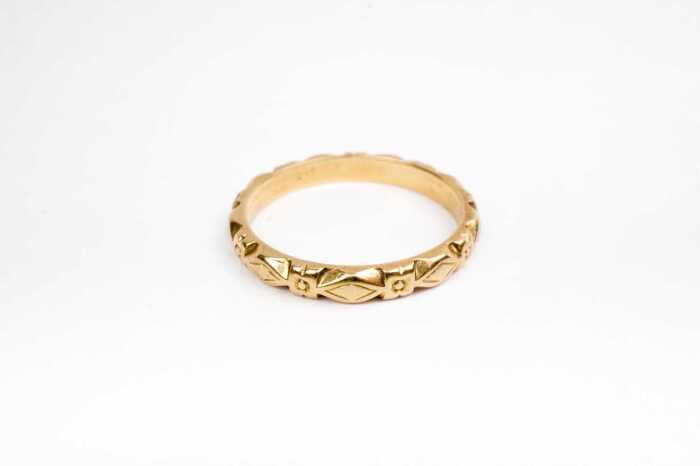 A patterned carved wedding band in 18ct yellow gold