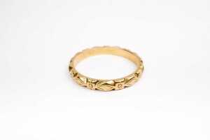 A patterned carved wedding band in 18ct yellow gold