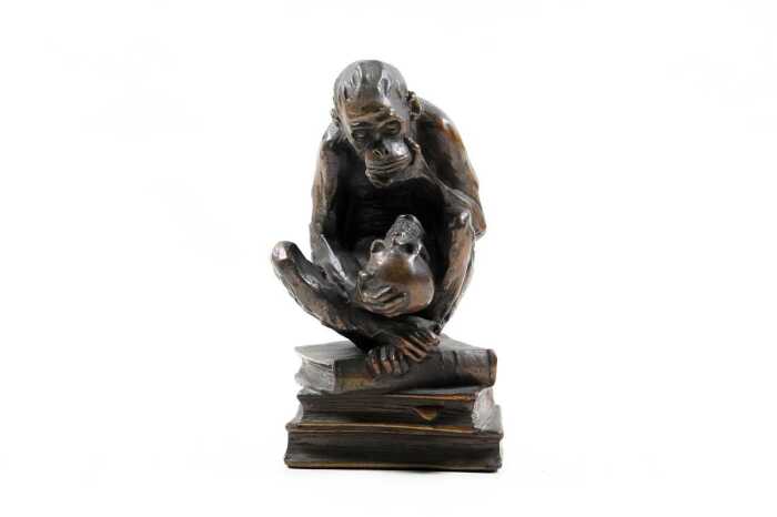 Bronzed figure of a monkey on books
